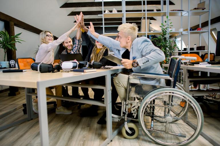personas en una reunión con una persona en silla de ruedas